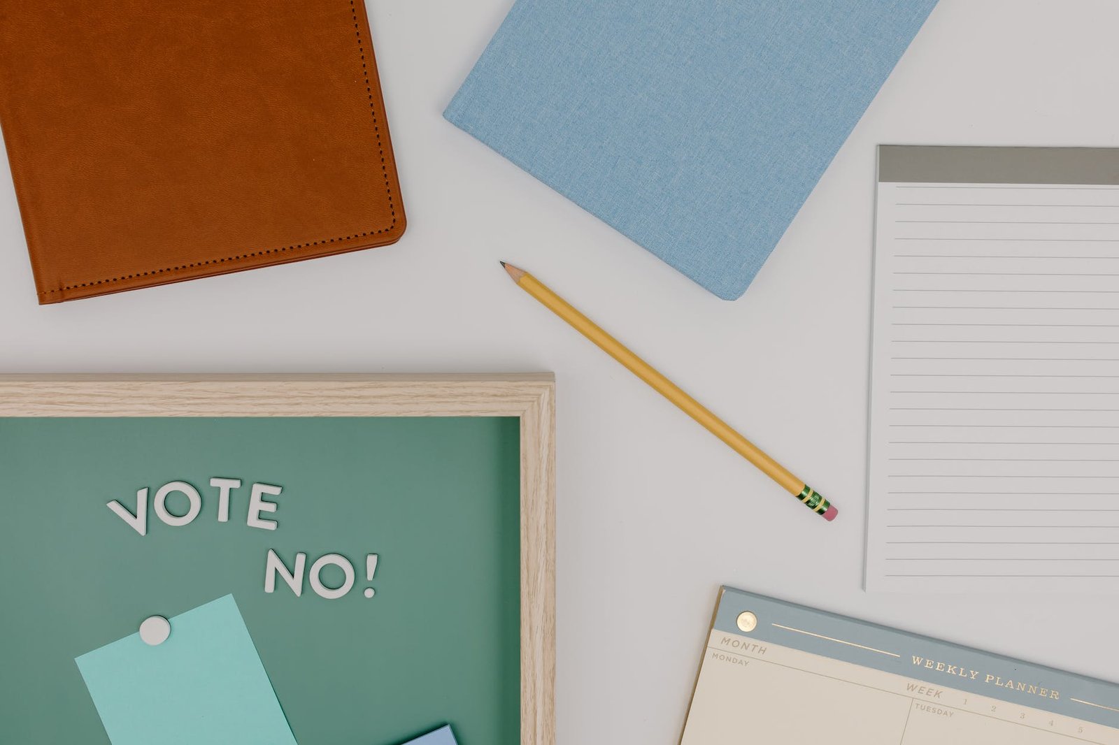 blue and white spring notebook beside brown pencil and pencil