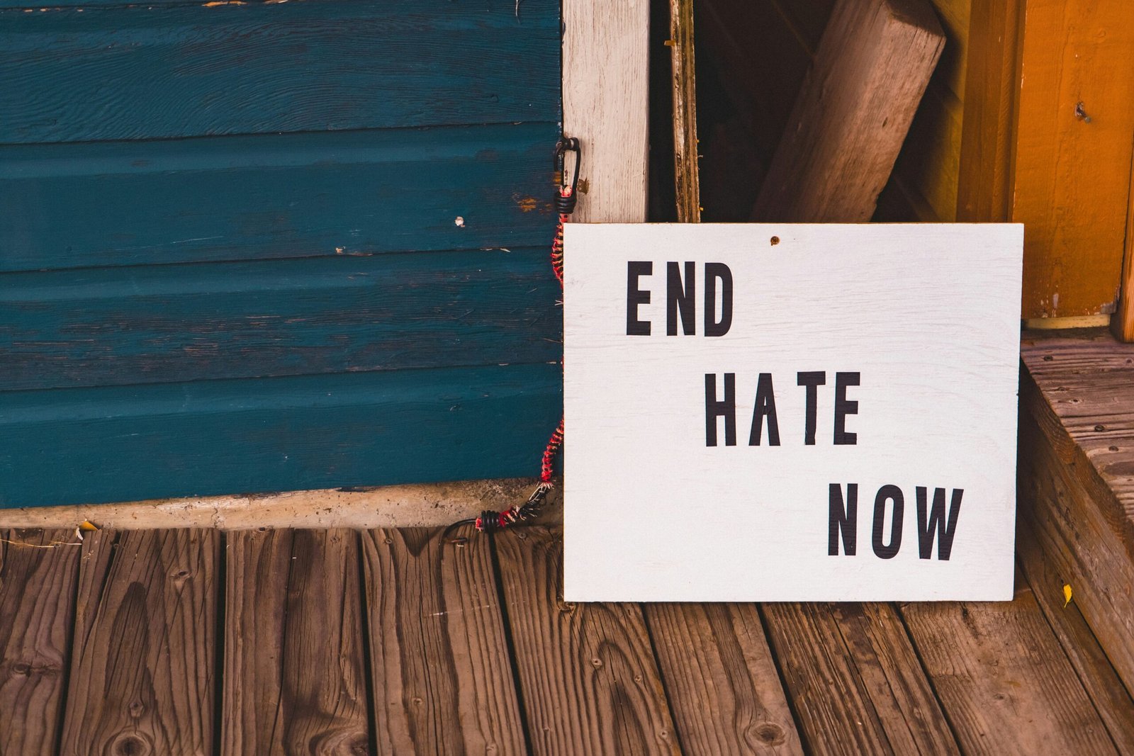 a sign that says end hate now on a porch