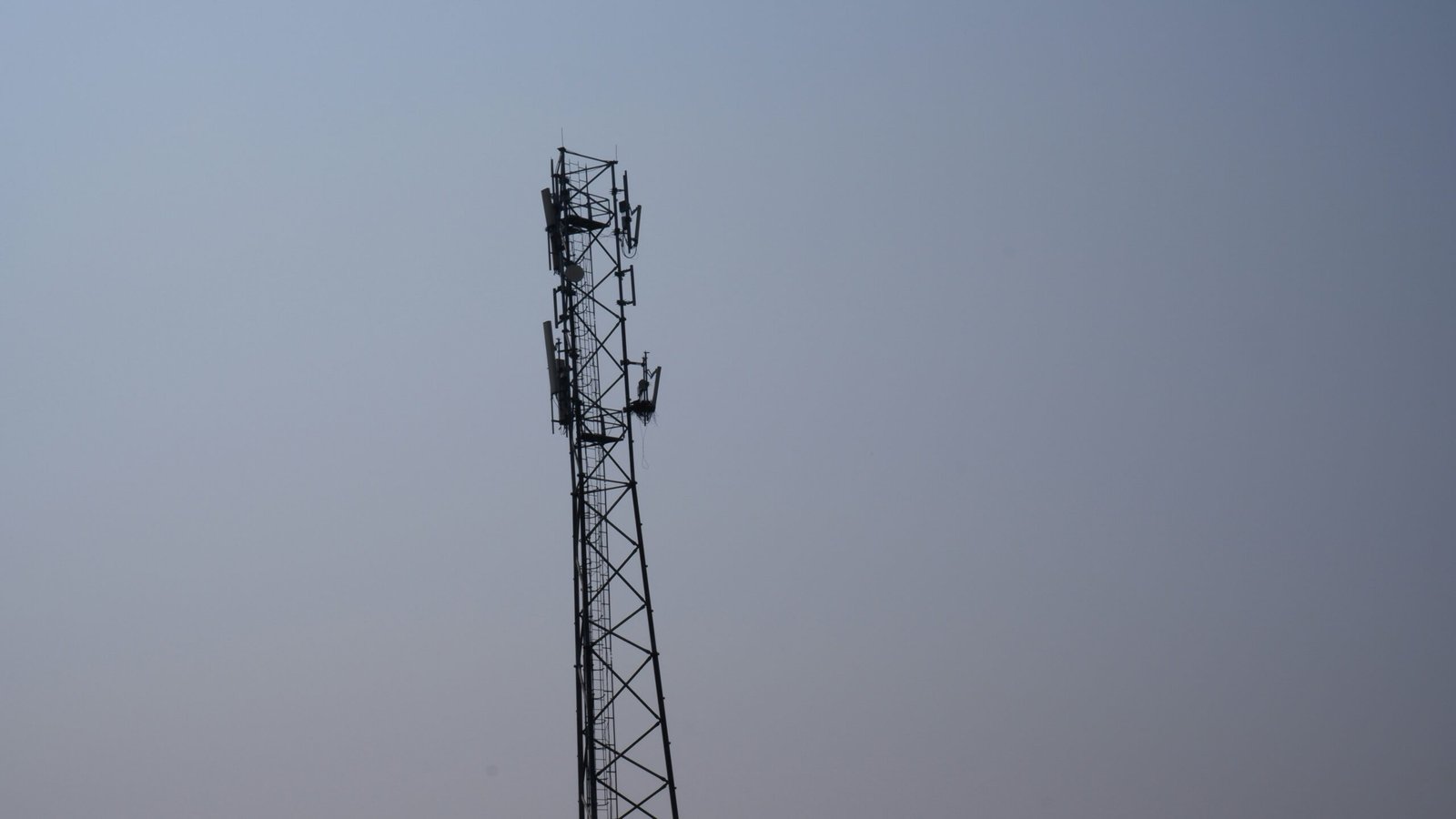 a tall tower with a cell phone on top of it