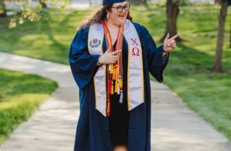 woman in blue academic dress standing on road during daytime